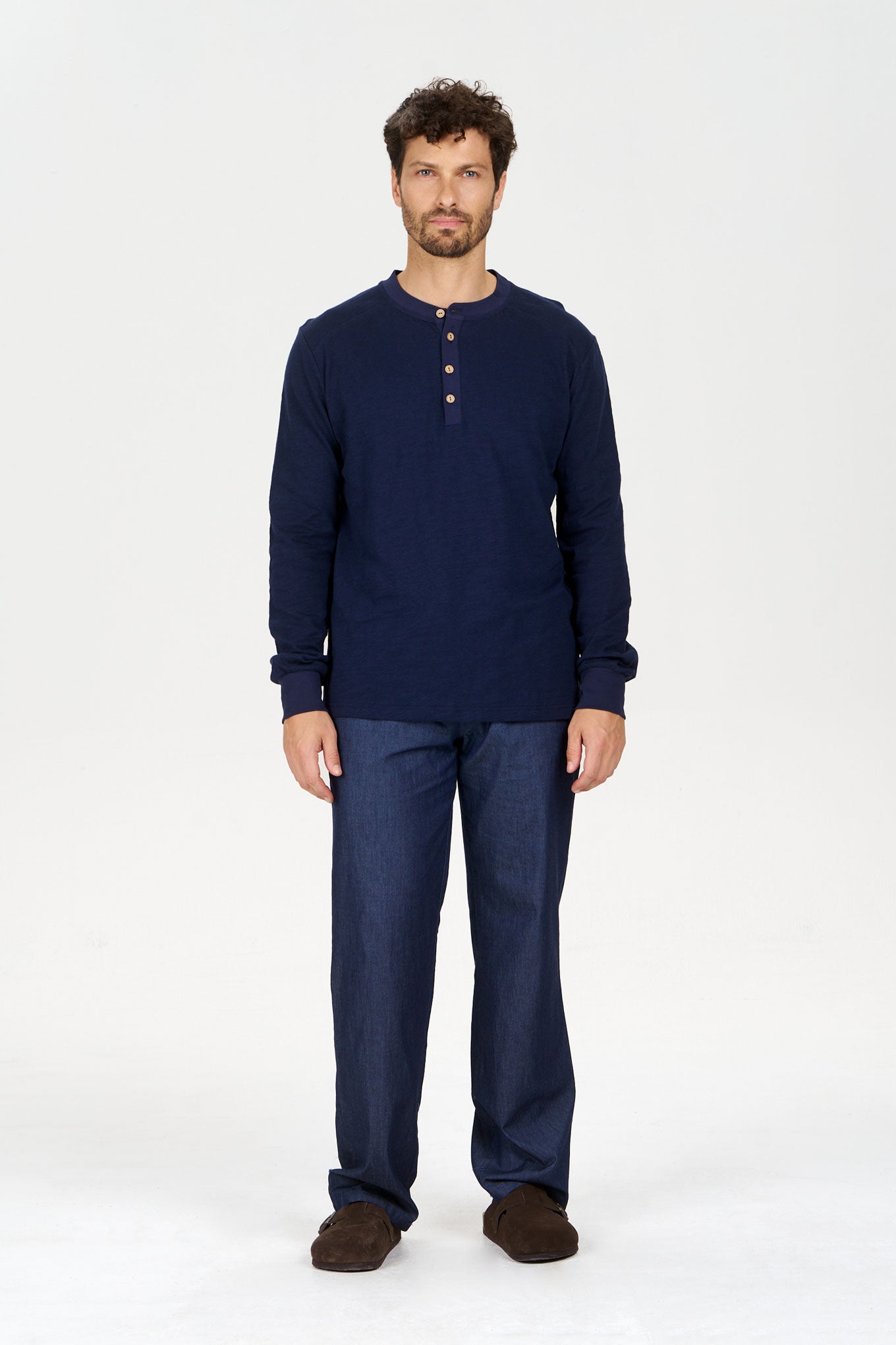 JOSHUA Organic Cotton Trouser - Mid Wash model wearing navy long sleeve henley shirt and trousers, showcasing a casual style.