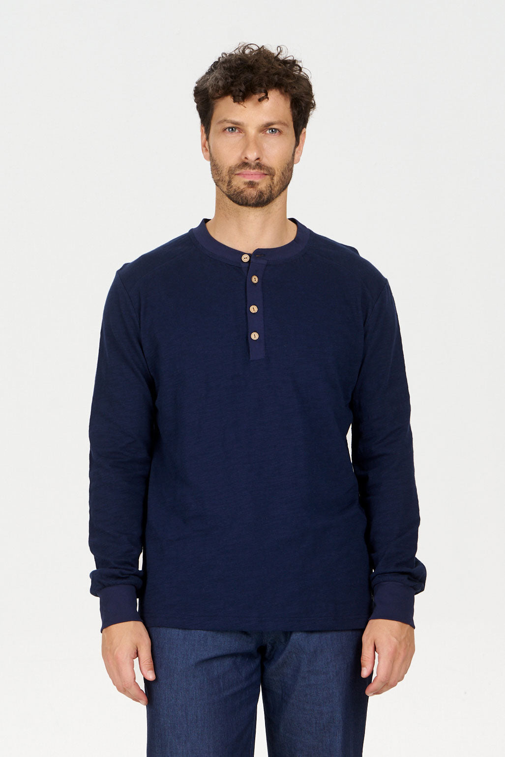 Model wearing the ARLO Organic Cotton Top in Navy, showing a loose fit, featuring a henley style with buttons, mens organic cotton jersey tee.