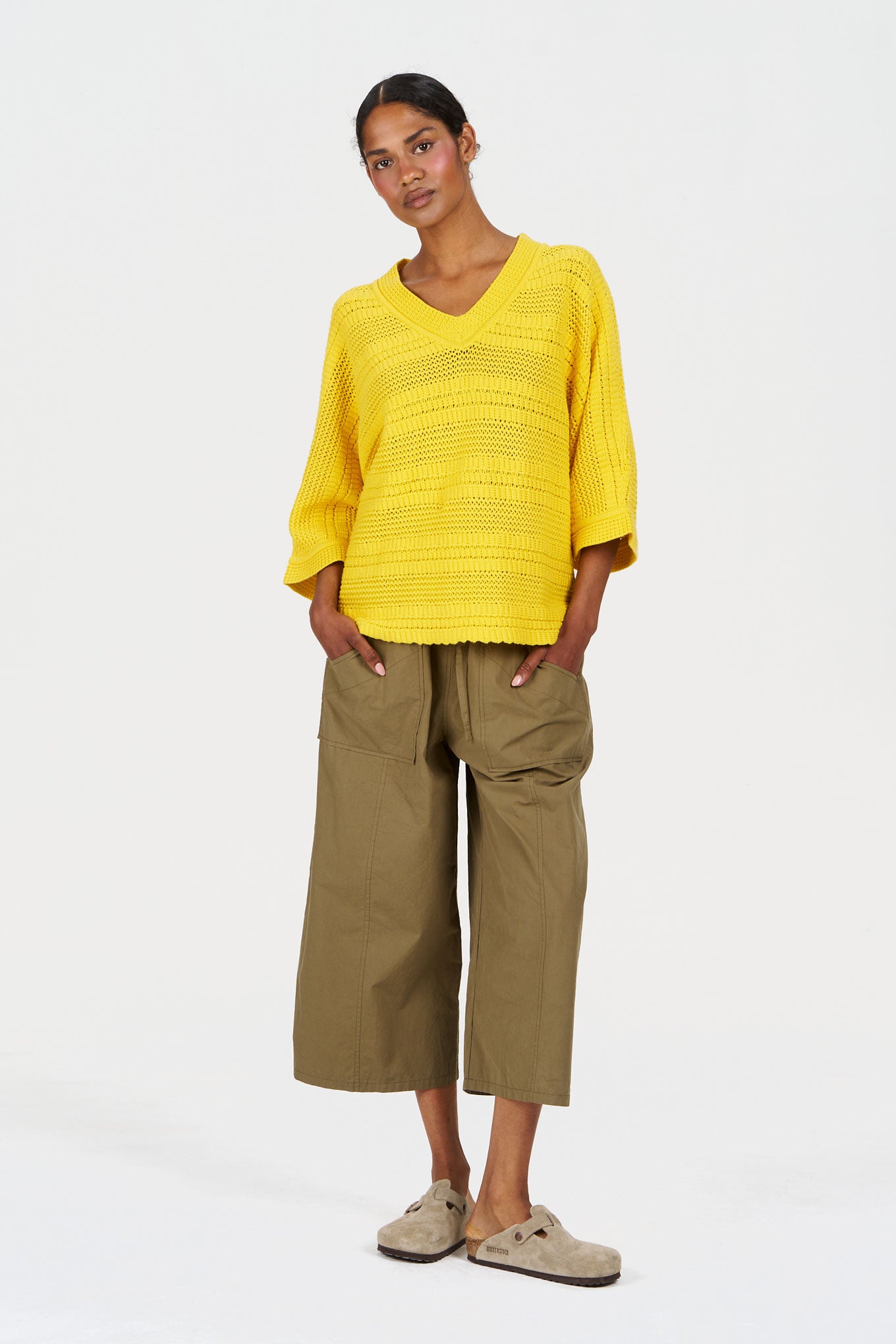 Model wearing CLEO Organic Cotton Trouser - Khaki with a yellow top, showcasing a stylish and sustainable outfit.