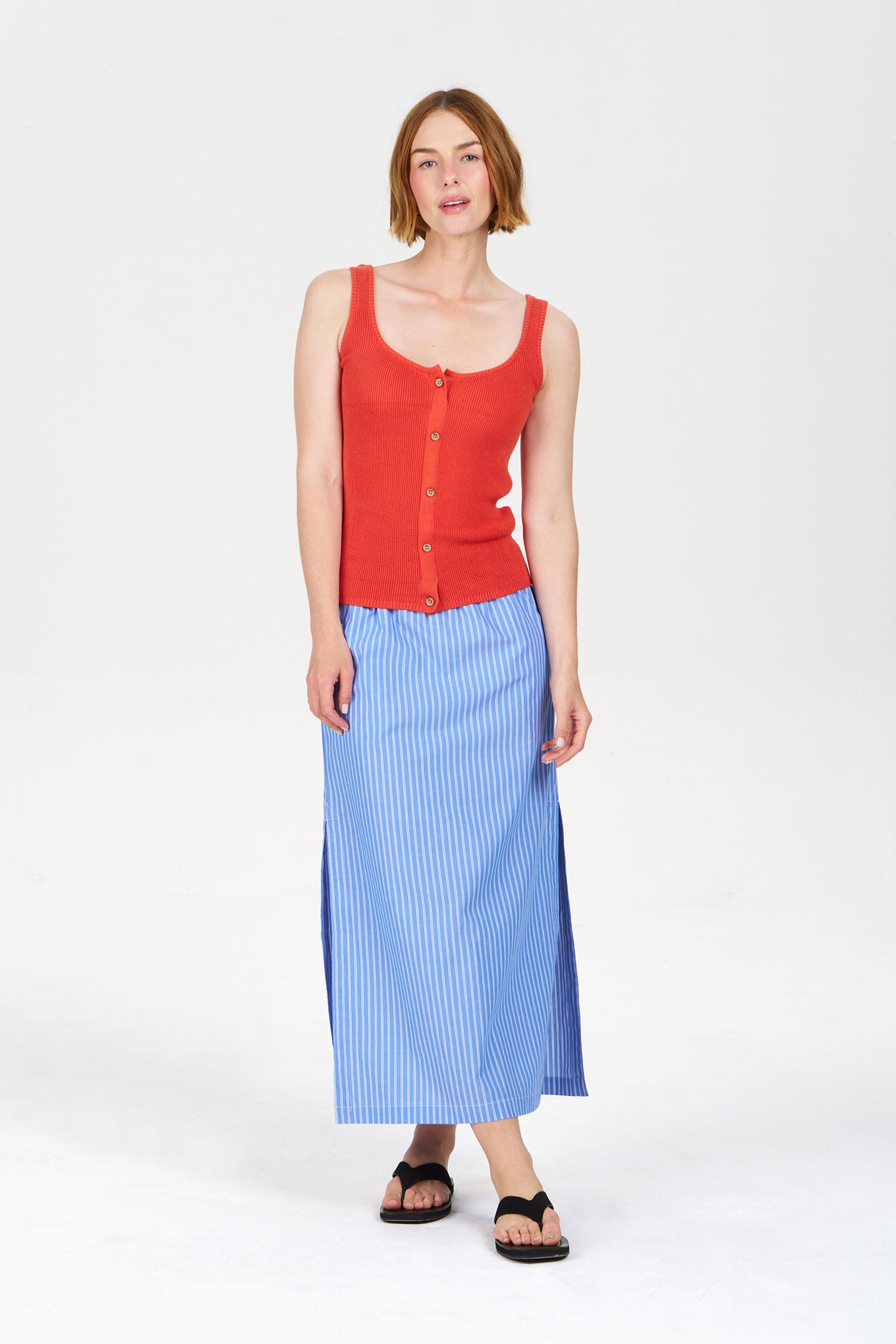 Model wearing a red tank top and LIELA Organic Cotton Skirt - Blue Stripe with a casual pose.