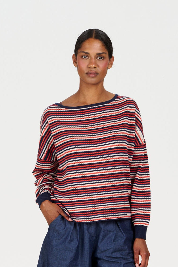 Model wearing a PINA Organic Cotton Jumper with red and navy stripes, showcasing a casual style.