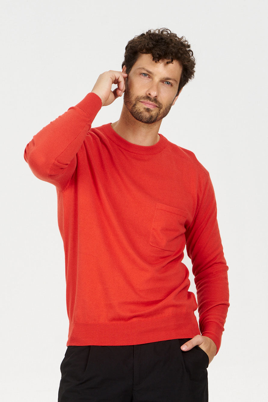 Model wearing a POCKET GOTS organic cotton jumper red with a pocket, showcasing a relaxed fit and vibrant color.
