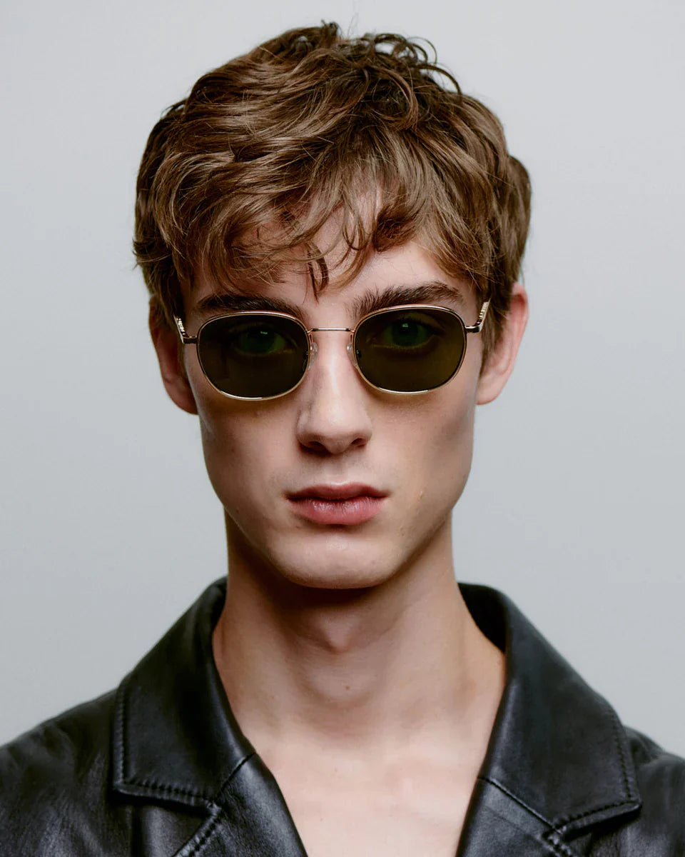 HELLO - Gold Sunglasses by A.Kjaerbede worn by a model with short hair and a leather jacket.