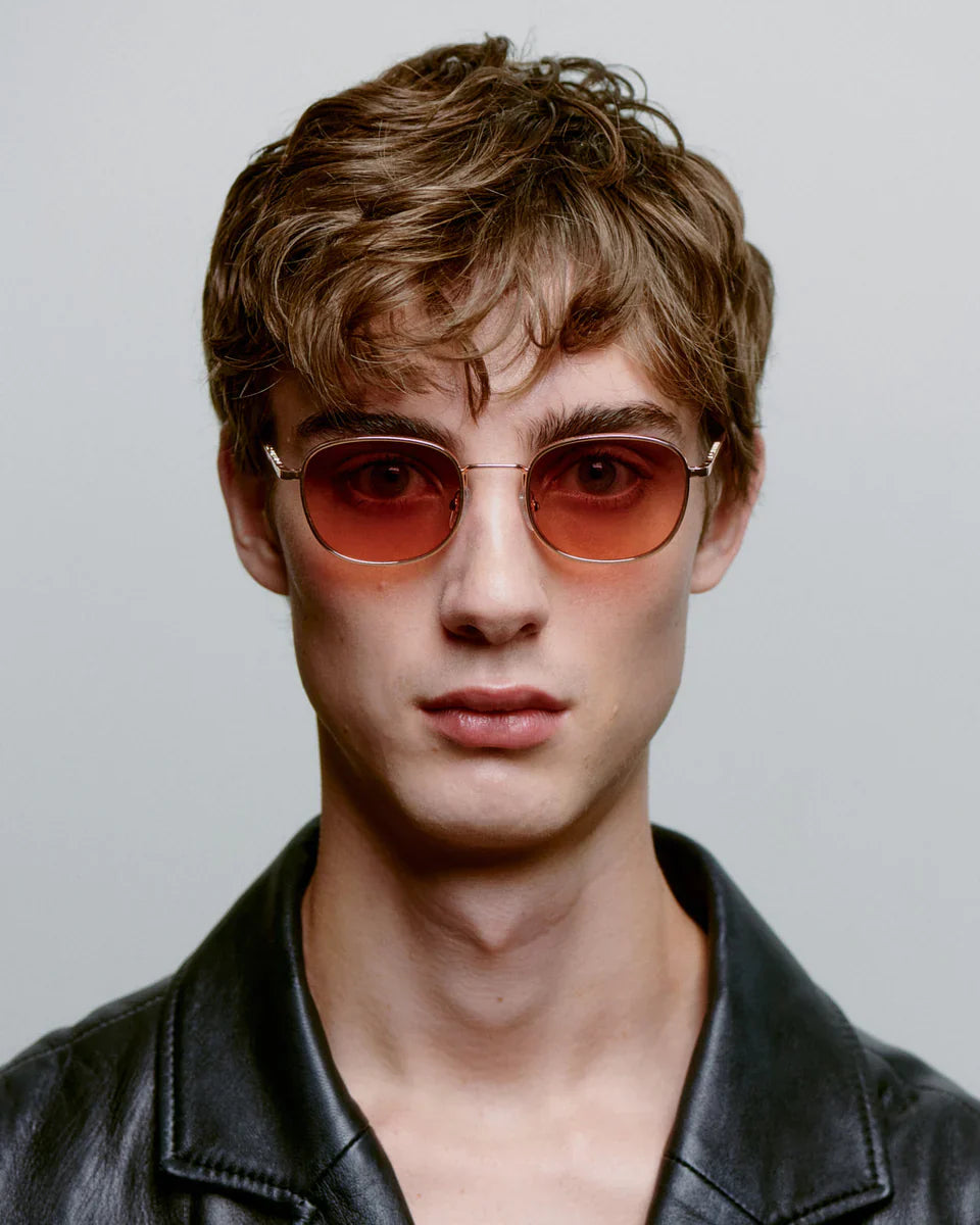 HELLO - Rosegold Sunglasses by A.Kjaerbede worn by a model with short, styled hair and a black leather jacket.