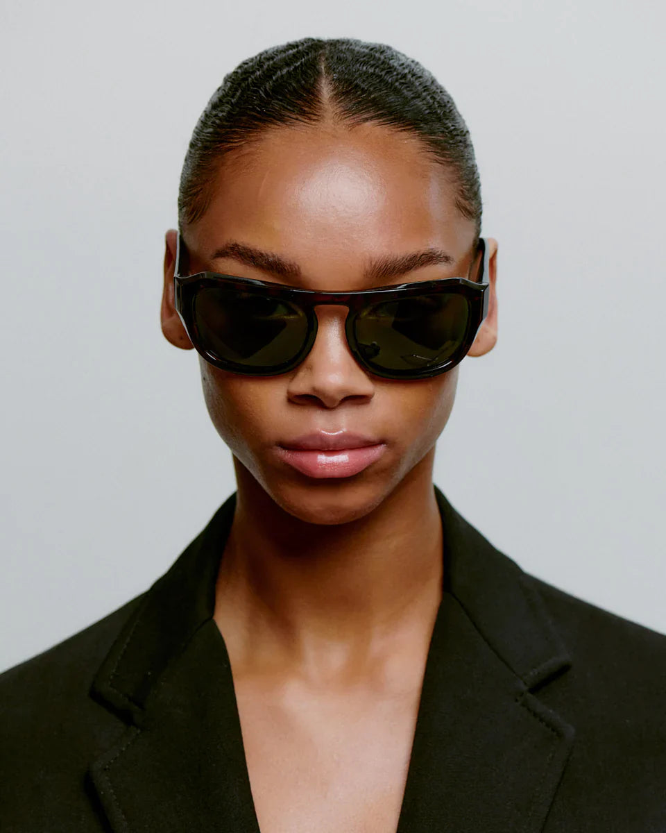 MAX - Demi Tortoise Sunglasses by A.Kjaerbede being worn by a model with sleek hair and a black blazer.