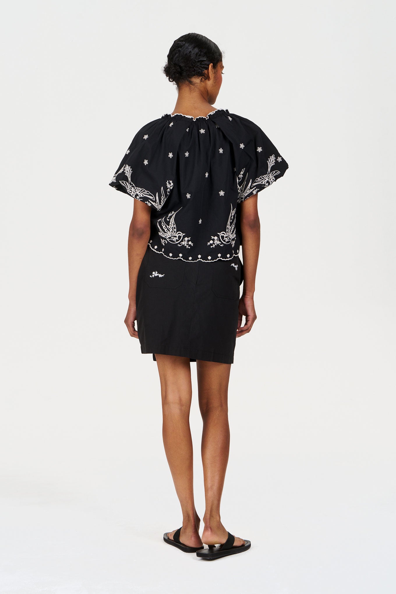 Model wearing a black back view of the WILLOW Organic Cotton Skirt - Black with a styled top.