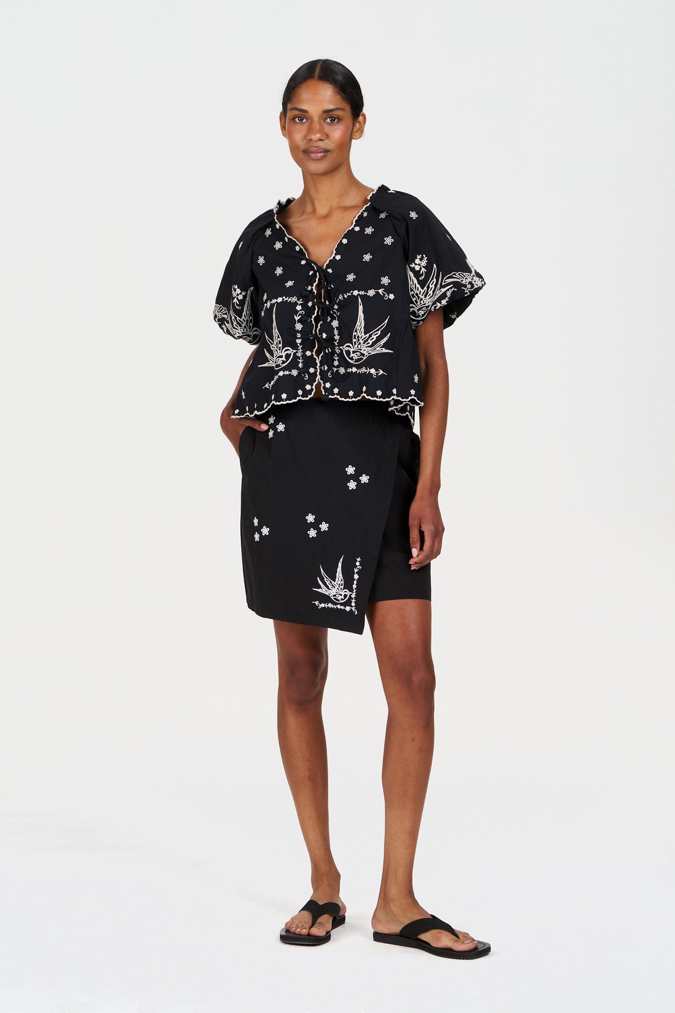 Model wearing WILLOW Organic Cotton Skirt - Black styled with a matching top, showcasing unique floral patterns.
