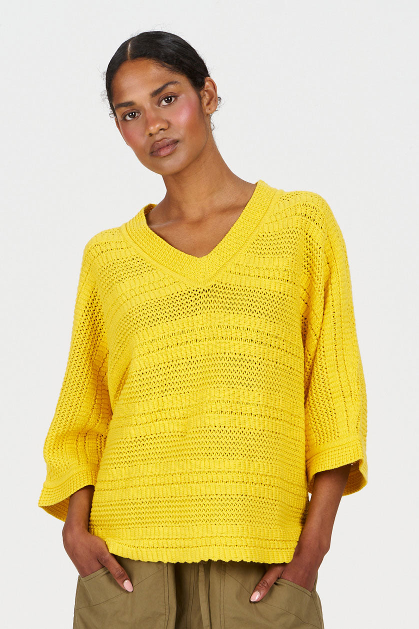 COLADA Organic Cotton Tee - Yellow worn by a model, featuring a relaxed fit and v-neck design.