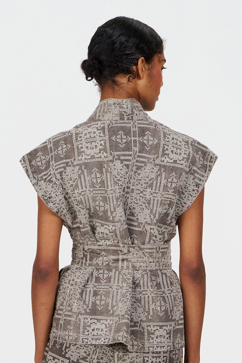 Back view of a woman wearing the GEORGIE Organic Linen Cotton Gilet - Mushroom Crossstich with a stylish pattern.