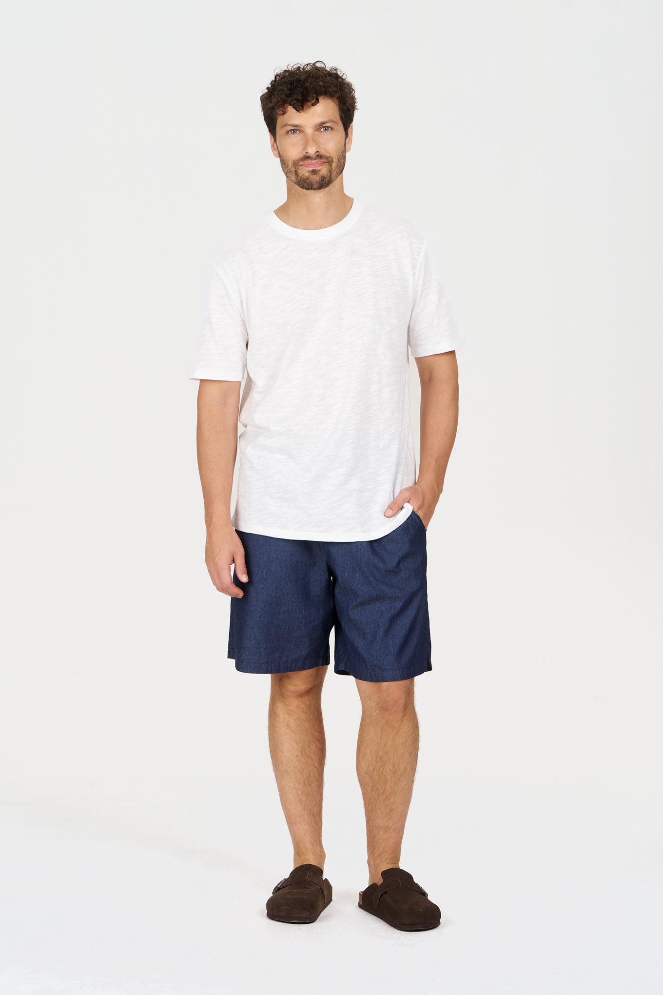 Model wearing JERRY Organic Cotton Short - Mid Wash paired with a white tee and brown slippers.
