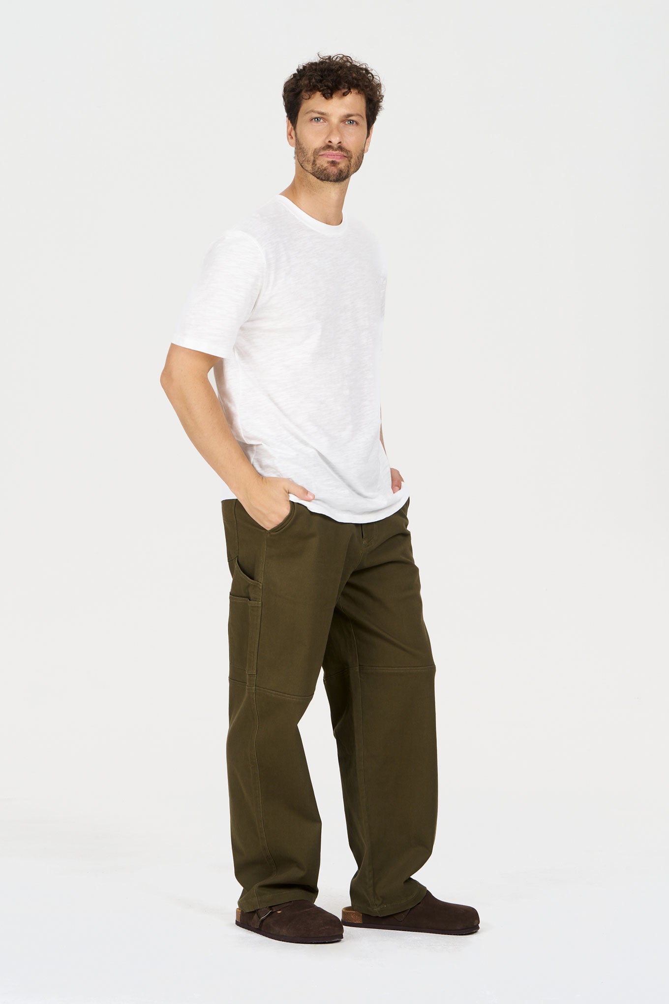 Model wearing THEO Trouser - Green paired with a casual white t-shirt, showcasing a relaxed fit and sustainable fashion.