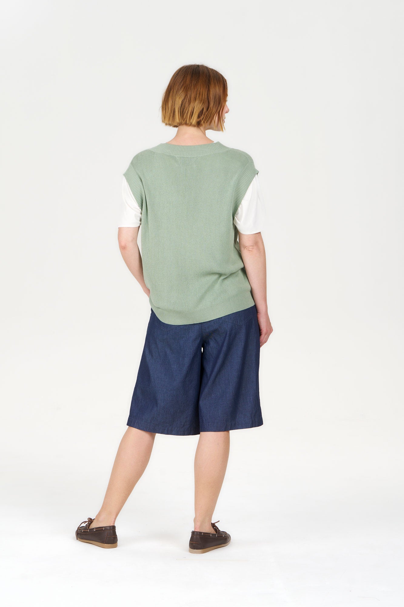 Model wearing SANDER Organic Ramie Cotton Vest - Sage paired with dark shorts, showcasing a casual and eco-friendly style.