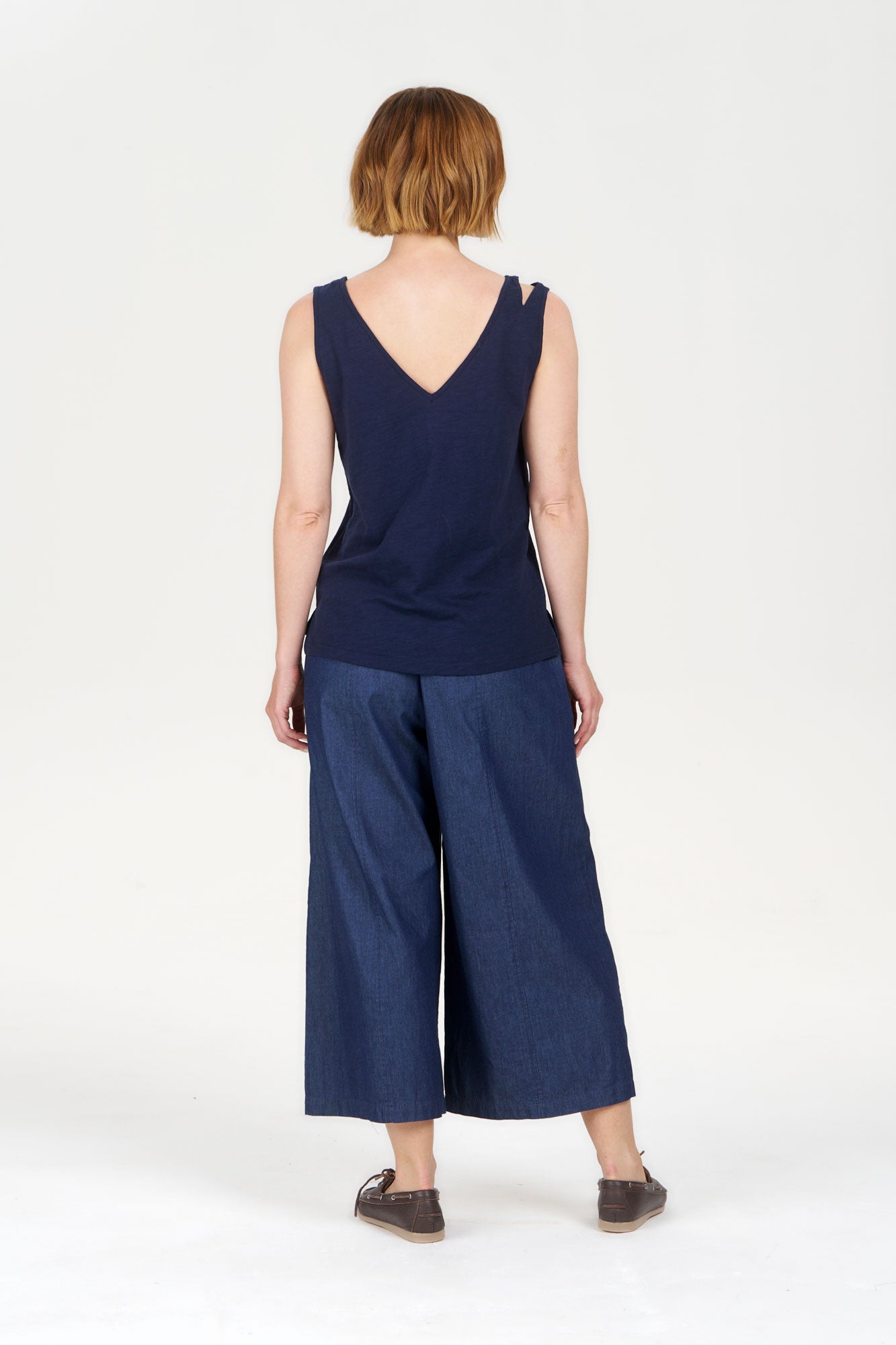 Person wearing a SANDER Organic Ramie Cotton Vest - navy from the back with wide-leg denim pants.