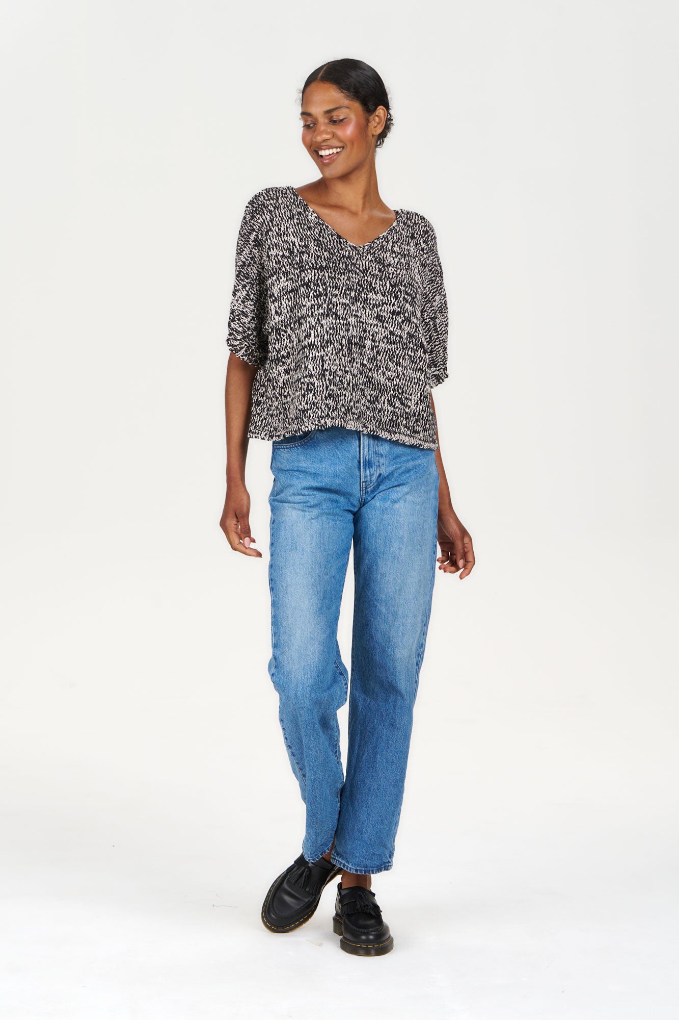 Model wearing a TERESA Organic Cotton Jumper - Black & White, paired with casual blue jeans and black shoes.