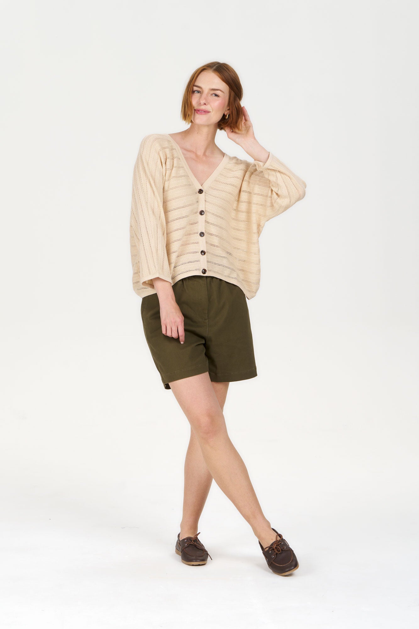 MALI Organic Ramie Cotton Batwing Cardigan - Sand worn with green shorts by a model in a light background.