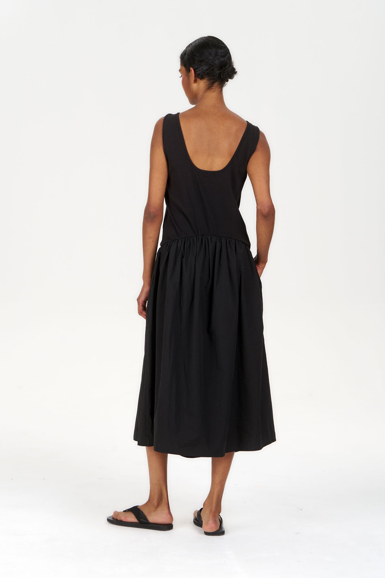 Model wearing NEEMA Organic Cotton Dress - Black, showcasing the back view of the stylish, breathable dress.