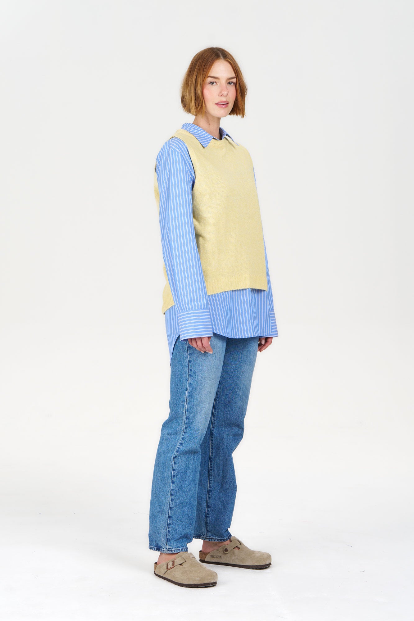 BLAKE Recycled Poly Vest - Yellow worn over a blue striped shirt, styled with casual jeans and beige shoes, fashion layering look.