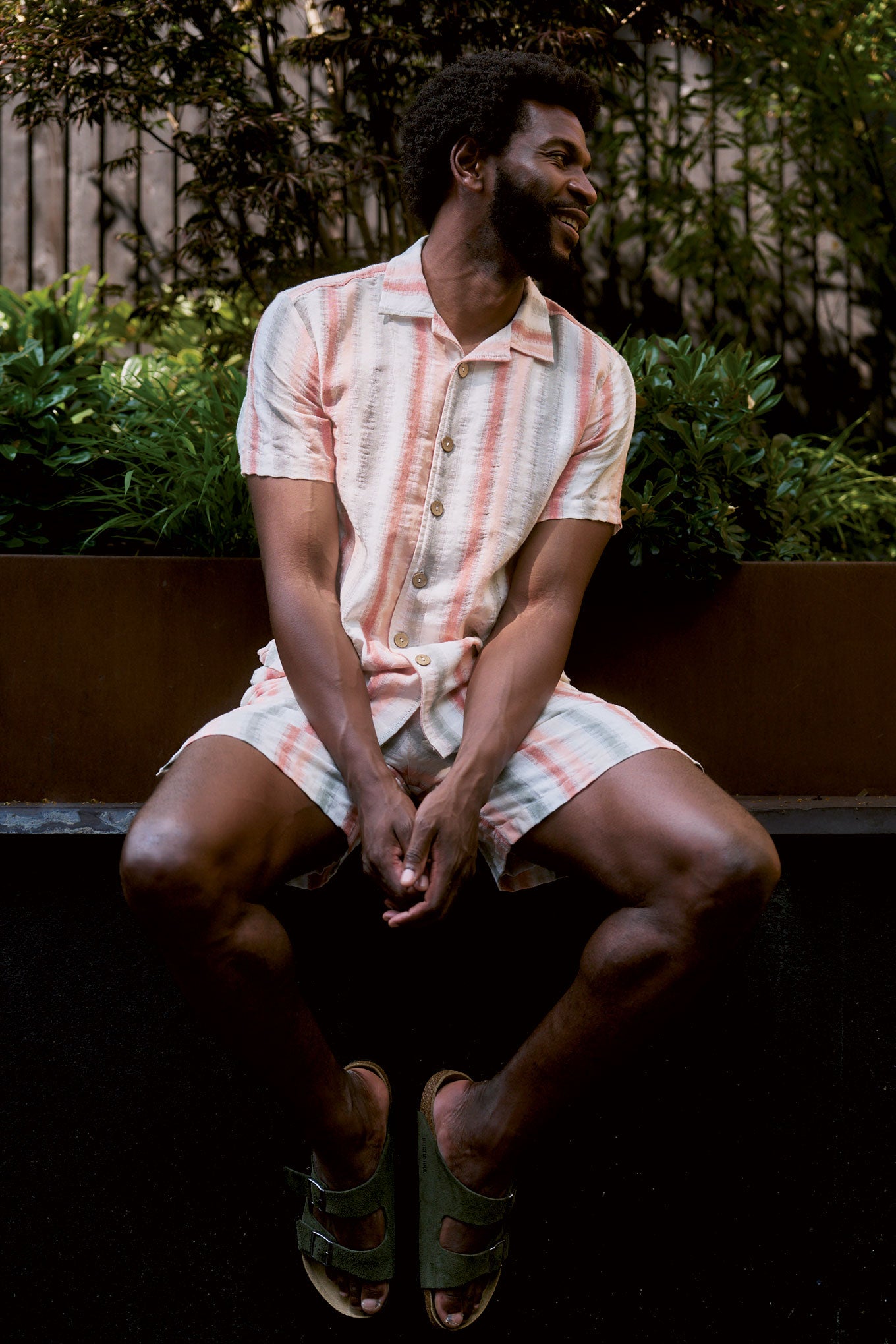 WAVE Organic Cotton Shirt worn by a man sitting in a garden, highlighting its stylish design and breathable fabric.