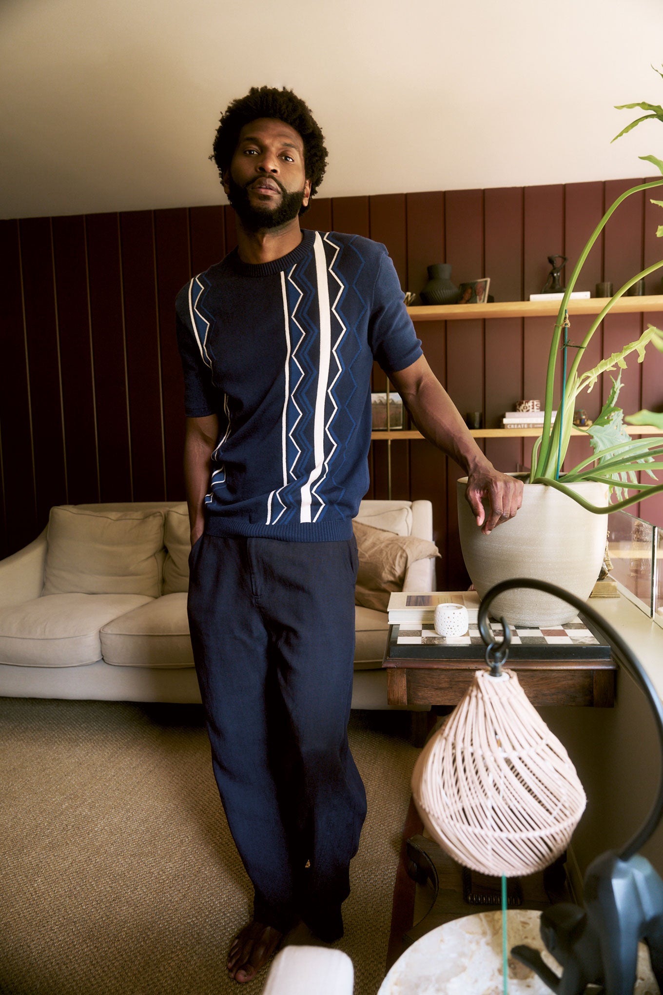 Model wearing RAFFI Organic Cotton Tee in a stylish living room setting with a relaxed look.