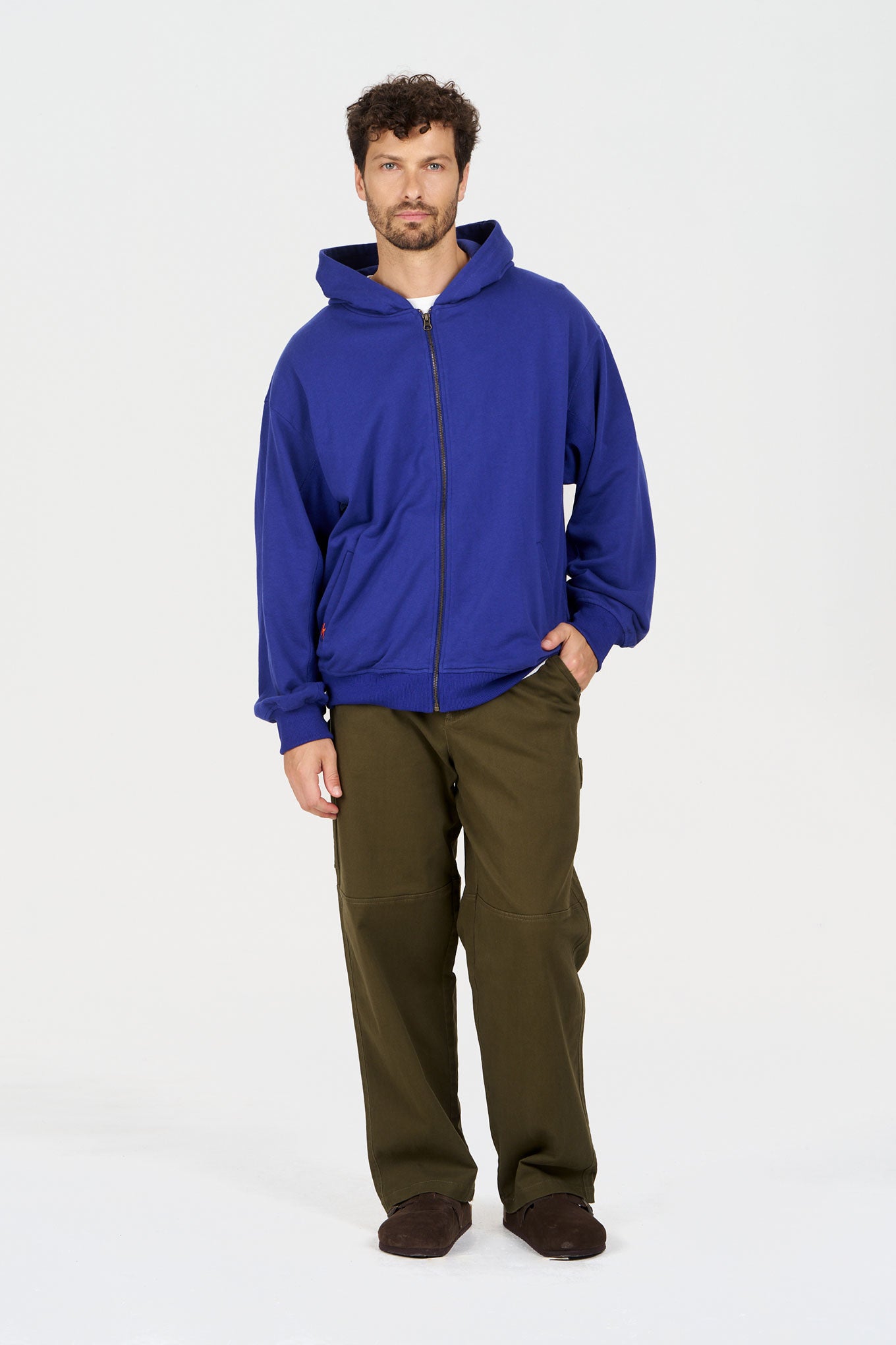 Model wearing THEO Trouser - Green with a blue hoodie, standing against a plain background.