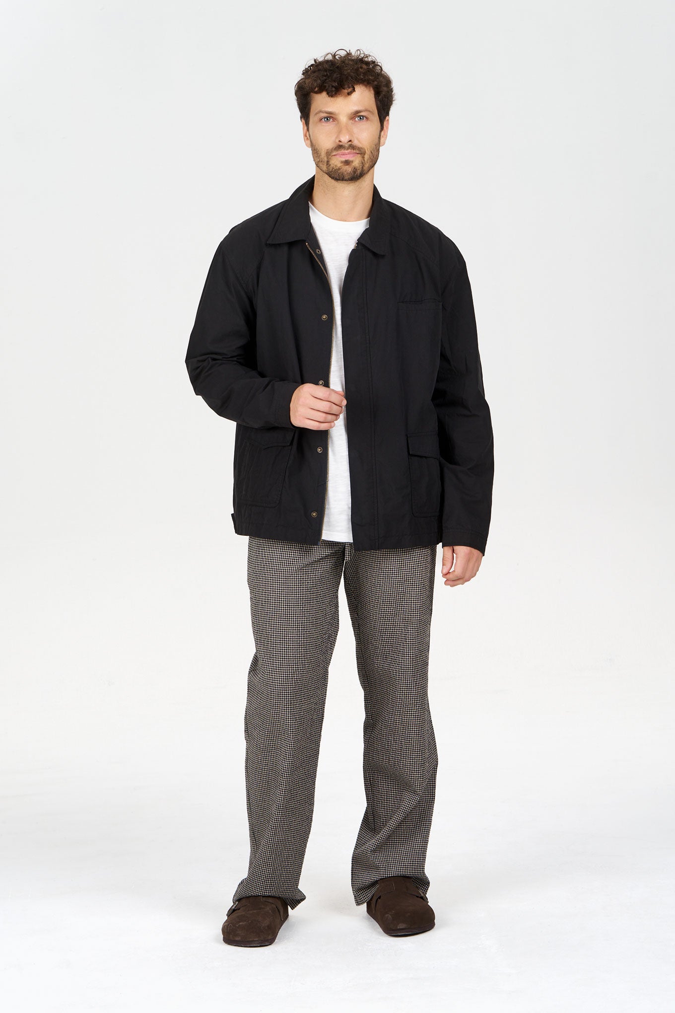RUDY Organic Cotton Jacket - Black worn by a man in casual setting, paired with light trousers and standing on a plain background.