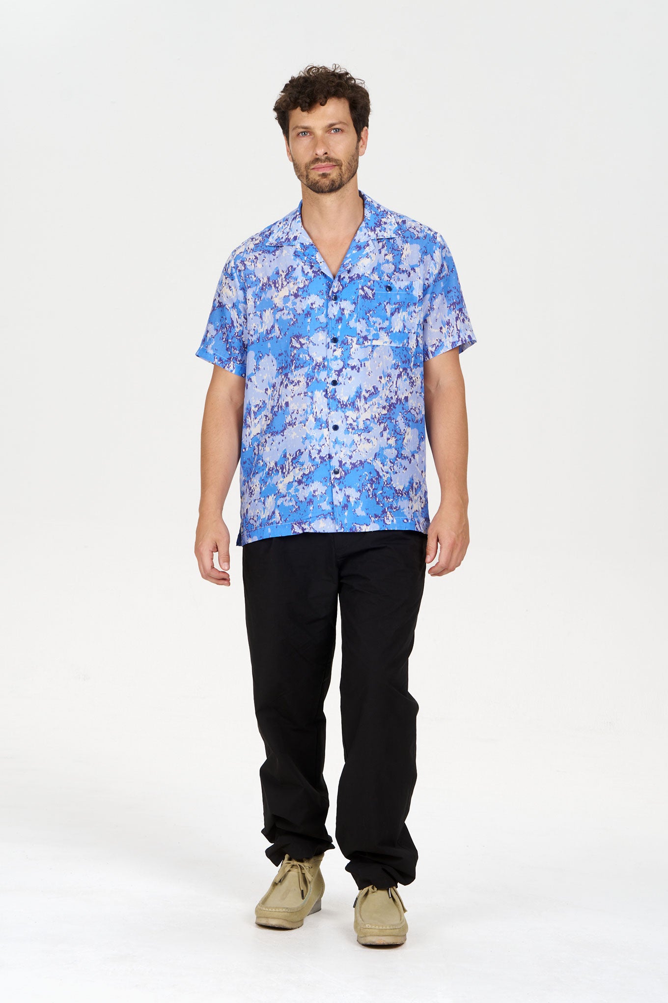 BOWIE Organic Cotton Trouser - Black with a model wearing a blue patterned shirt and relaxed fit black trousers.